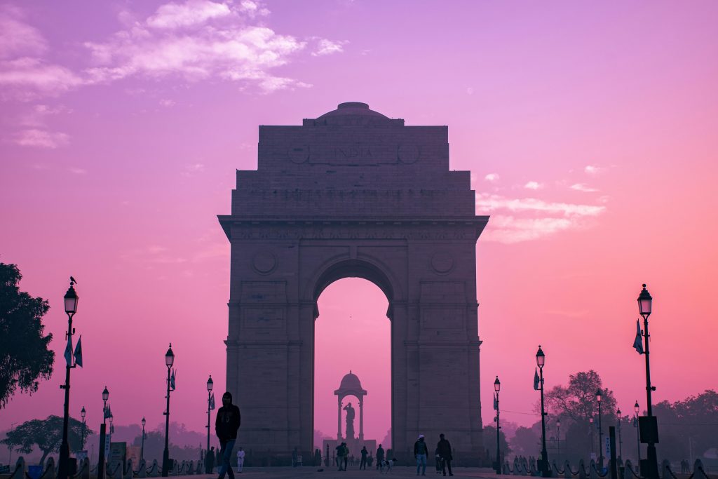 Stunning silhouette of India Gate during a pink sunrise in New Delhi, India.